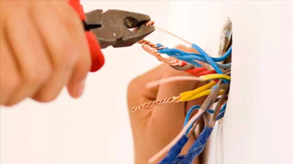 Alicate e fios dentro de uma caixa de parede